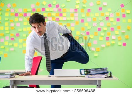 Man in the office with many conflicting priorities doing exercis