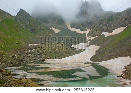 Partially Frozen Didighali Lake With A Mountain Pass In The Background On A Hiking Trail In Caucasus