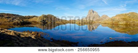 Midi Dossau Peak reflected in a lake. Ossau Valley, Pyrenees National Park, Pyrenees, France.