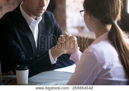 Serious Man And Woman Armwrestling At Workplace