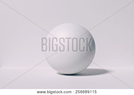 3d white concrete sphere againstwhite wall