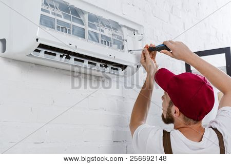 Close-up Shot Of Professional Repairman Changing Filter For Air Conditioner With Screwdriver