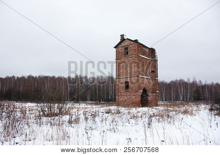 Old abandoned brick oast house in a field