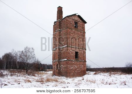 Old abandoned brick oast house in a field