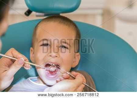 Pediatric Dentist Examining A Little Boys Teeth In The Dentists Chair At The Dental Clinic. Dentist 