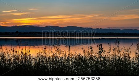 sunset over Fronts Range of Rocky Mountains with one of numerous lakes in northern Colorado