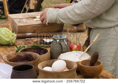 Medieval Food Preparation Including Bread, Butter, Cheese, Fruit In Wooden Bowls Or Trenchers