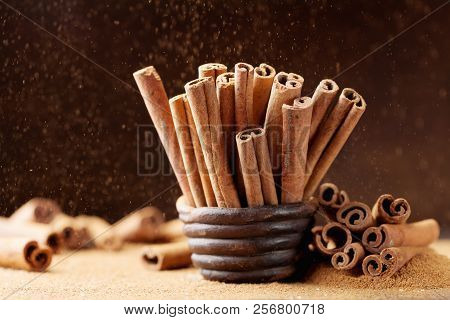 Heap Of Cinnamon Sticks And Ground Cinnamon With Dust Effect. Aromatic Spice.