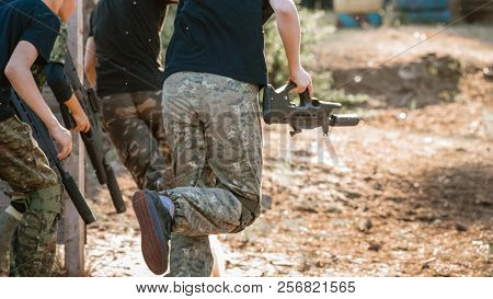Group Of Men With Guns Playing Lasertag Game In Forest