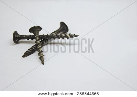 Three Old Screws On A White Bacjground
