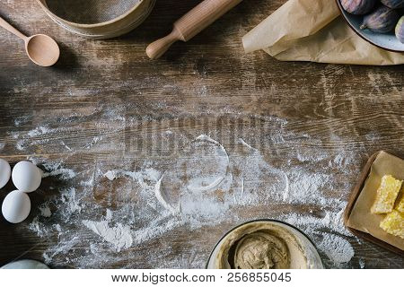 Top View Of Messy Rustic Wooden Table With Spilled Flour And Baking Ingredients