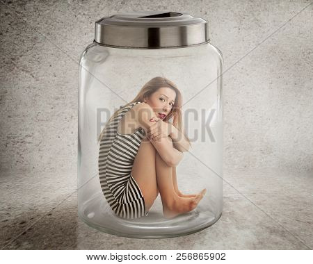 Lack, Violation Of Human Rights Liberty. Young Lonely Woman Sitting In Glass Jar Isolated Grey Wall 