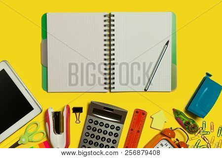 Multiple School And Office Suplies And Gadgets Lying On A Yellow Surface