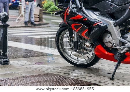 Large Motorcycle Leaning On Its Stand In The Rain In The City Street