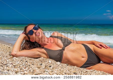 woman sunbathing on the beach summer travel holidays