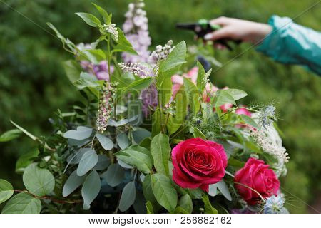 ST. PETERSBURG, RUSSIA - JULY 20, 2018: Florist of Mila Schumann Studio Flowers & Design prepares the bouquet for the festival Imperial Bouquet in the park of State Museum Pavlovsk