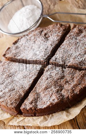 Traditional Swedish Kladdkaka Chocolate Cake Sliced On Parchment Close-up. Vertical