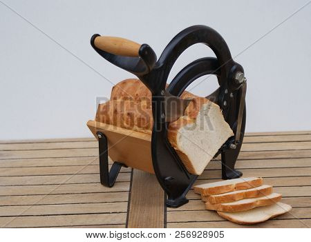 Old Danish Bread Slicer On Wooden Background With White Bread Slices