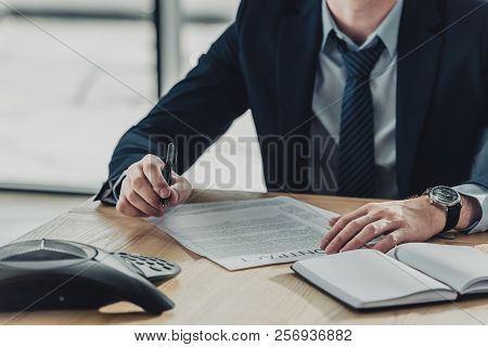 Cropped Shot Of Businessman Signing Contract At Wokplace