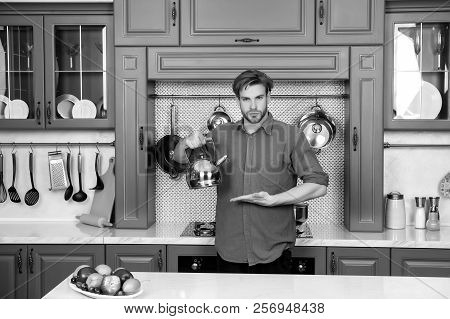Man In Blue Shirt Point Hand At Kettle. Kitchen Appliance And Furniture. Presenting Product, Online 