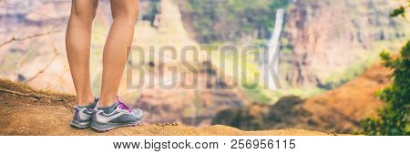 Hiking girl walking in mountains travel closeup of feet and legs walking in running shoes, banner panorama lansdcape background.