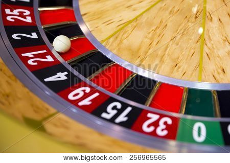 Roulette Table In Casino. Ball In The Rotating Gambling Machine. Wooden Roulette Wheel.