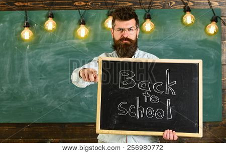 Man With Beard And Mustache On Strict Face Warns Students, Pointing Forward, Chalkboard On Backgroun