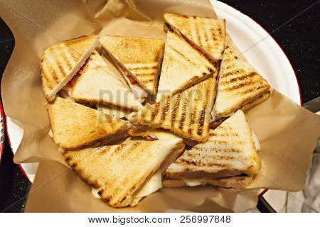 Top View, Triangle Shaped, Toasted White Bread Club Panini Sandwiches With Ham, Cheese And Tomato
