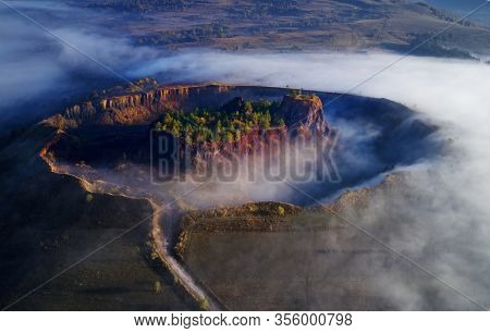 aerial view of volcanic crater in Racos village, Brasov county, Romania - foggy autumn morning