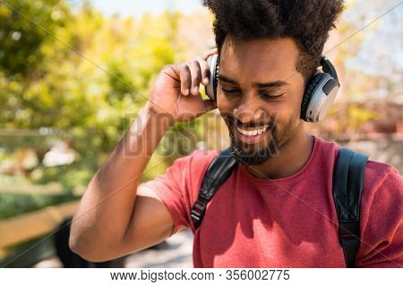 Young Afro Man Listening To Music With Headphones.