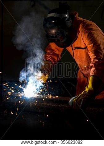Metal Industry Workers Are Welding Steel Sheets For Real Estate Projects Received. Sparkler On Dark 