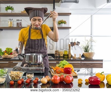 The Maid Is Doing The Meat Stew In A Modern Kitchen.