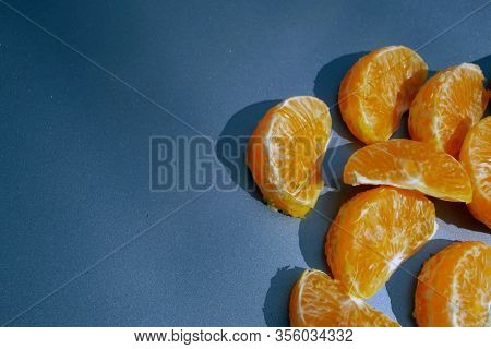 Pieces Of Orange Mandarin On A Gray Background