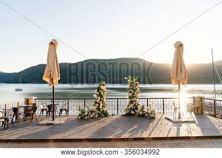 Wedding Decor. Arch Of Flowers For The Ceremony In The Background Of Lake Abrau Dyurso