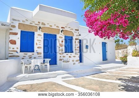 Traditional Yard With Blue Windows And Bougainvilleas At Koufonisia Islands Greece