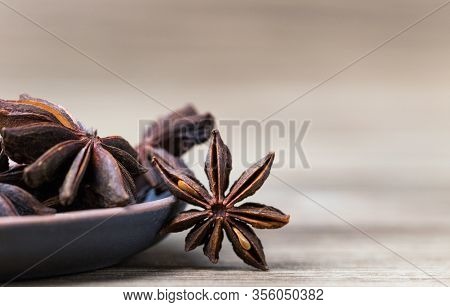Star Anise With And Without Seeds, In A Clay Dish On A Light Wooden Surface. Spice For The Recipe. B