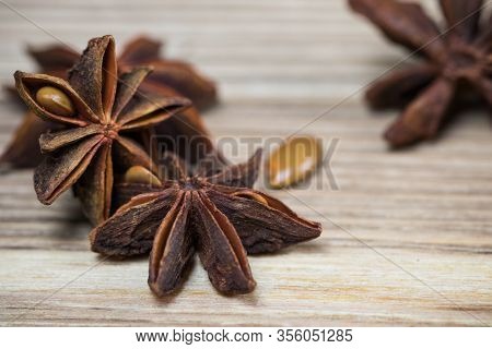 Star Anise With And Without Seeds, Closed, On A Light Wooden Surface. Spice For The Recipe. Beautifu