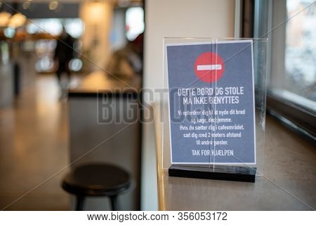 Copenhagen, Denmark - March 17, 2020: A Sign In A Cafe Informing About Closed Tables And Minium Dist