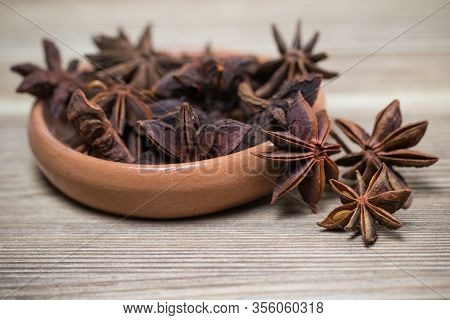 Star Anise With And Without Seed, Closed, In A Clay Plate On A Light Wooden Surface. Spice For The R