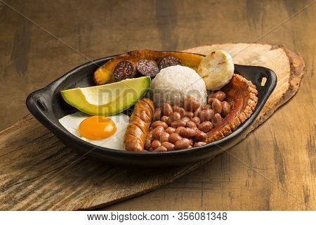Bandeja Paisa, Typical Dish At The Antioqueña Region Of Colombia. It Consists Of Chicharrón (fried P