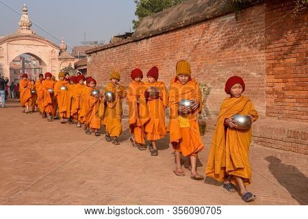 Young Buddhist Monks Walking In Morning Alms At Bhaktapur On Nepal