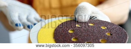 Close-up Of Male Hands Holding Orbital Sander Machine Discs. Man In Protective Gloves In Hardware Sh