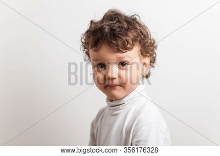Portrait Of A Bold Boy With Curly Hair Of Three Years On A White Isolated Background
