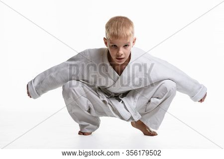 Martial Arts Student Dressed In A Kimono Performs A Squat