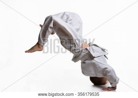 Judo Boy In White Kimono Doing Somersault