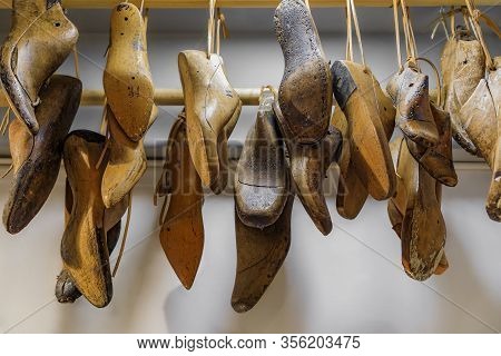 Selection Of Italian Footwear Shoe And Boot Forms Or Lasts For Custom Shoemaking Hanging In A Leathe