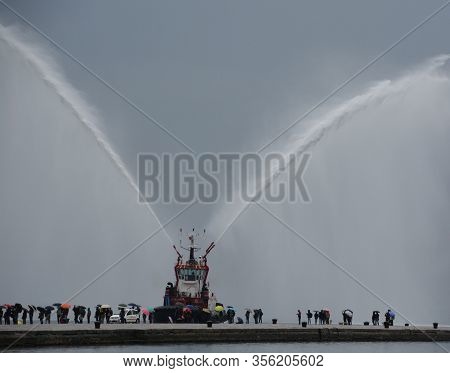 Trieste Italy 05 19 2019: Deneb Tug Boat In Trieste Italy Giving Farewell Salute With Fire Hoses Wit