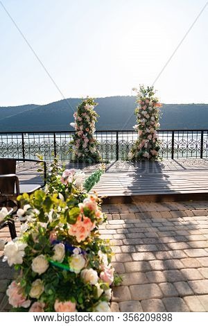 Wedding Decor. Arch Of Flowers For The Ceremony In The Background Of Lake Abrau Dyurso