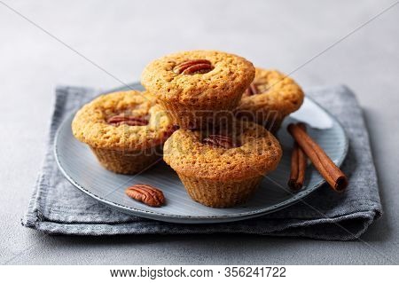 Pecun Nut Muffins On A Plate. Grey Background. Close Up.