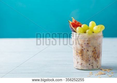 Overnight Oats, Bircher Muesli With Grape And Figs. Blue Background. Copy Space.